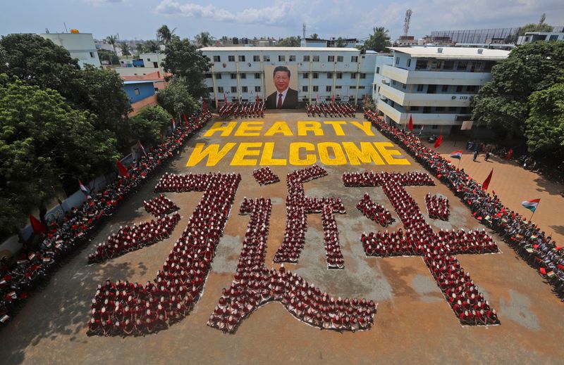 &copy; Reuters. FILE PHOTO: Students wearing masks of China&apos;s President Xi Jinping sit in a formation that reads &quot;Welcome&quot; in the Mandarin language, ahead of the informal summit with India’s Prime Minister Narendra Modi, at a school in Chennai