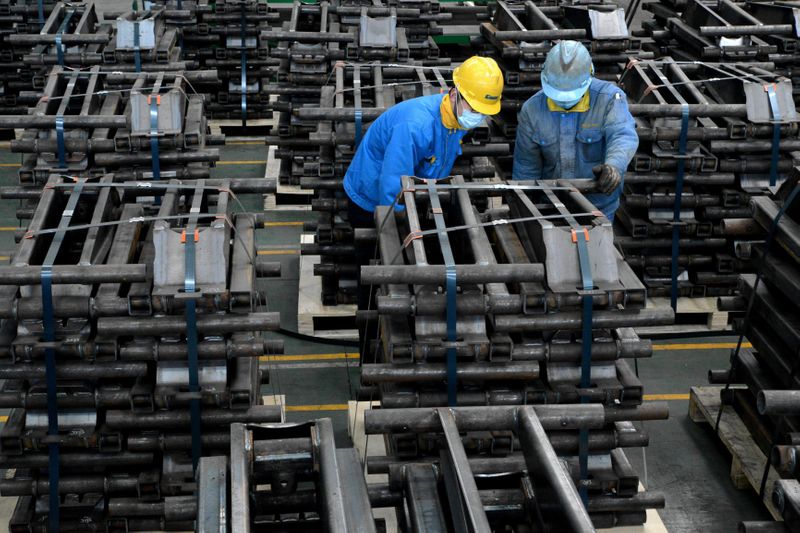 &copy; Reuters. Workers wearing face masks are seen on a production line manufacturing parts for trailers to be exported to U.S. at a factory, as the country is hit by an outbreak of the novel coronavirus disease (COVID-19), in Taizhou