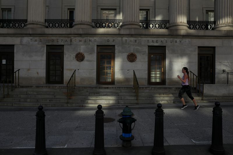 © Reuters. Una mujer corre por una calle casi vacía en el brote de coronavirus cerca del Departamento del Tesoro en Washington