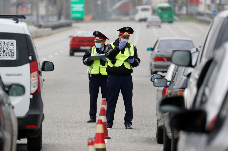 &copy; Reuters. Полицейские проверяют документы водителей на КПП в Алма-Ате