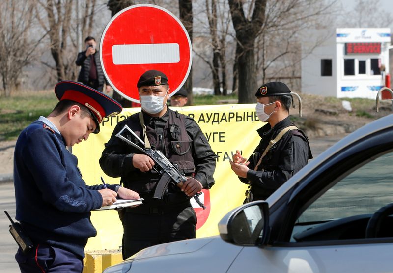 © Reuters. Сотрудники правоохранительных органов на КПП в Алма-Ате