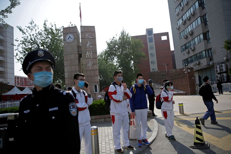 © Reuters. FILE PHOTO: Students wearing face masks leave a school in Beijing