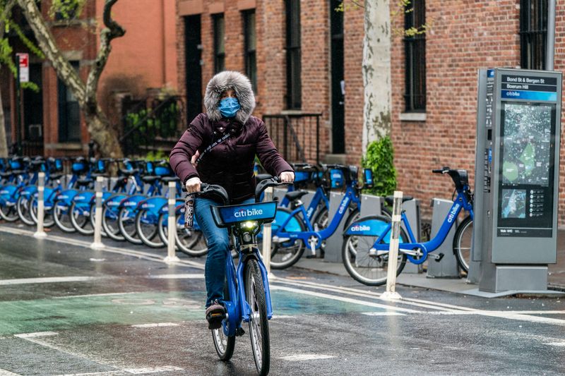 &copy; Reuters. Mulher com máscara de proteção anda de bicicleta em Nova York