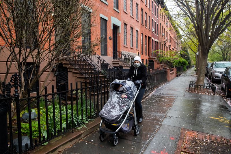 © Reuters. Mulher passeia com seu bebê usando máscara de proteção em Nova York