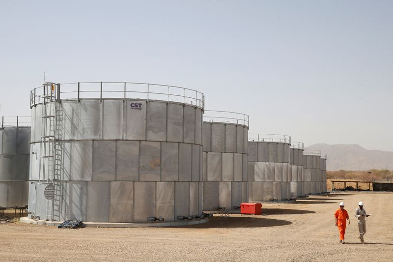 &copy; Reuters. FILE PHOTO: Workers walk past storage tanks at Tullow Oil&apos;s Ngamia 8 drilling site in Lokichar