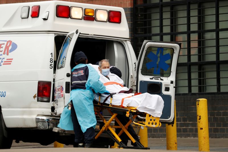 © Reuters. Profissionais de saúde retiram paciente de ambulância no hospital Elmhurst, em Nova York (EUA)