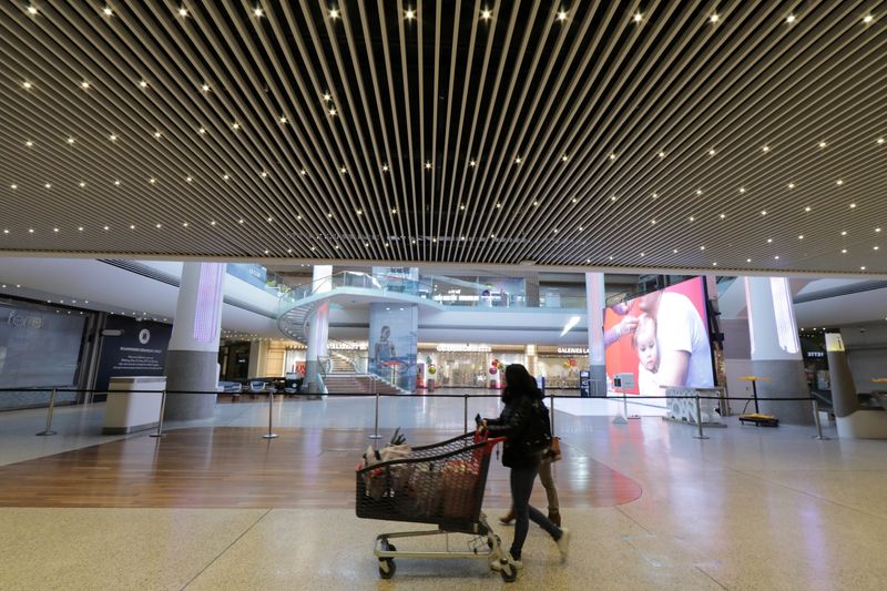 &copy; Reuters. A woman pushes a shopping trolley past to closed shops at CAP3000 shopping mall in Saint-Laurent-du-Var