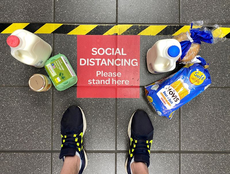 &copy; Reuters. FOTO DE ARCHIVO: La compra de alimentos se ve en el suelo junto a un signo de distanciamiento social y marcas mientras un cliente espera en una cola en un supermercado de Spar, tras el brote de la enfermedad coronavirus (COVID-19) en Hemel Hempstead, Rein