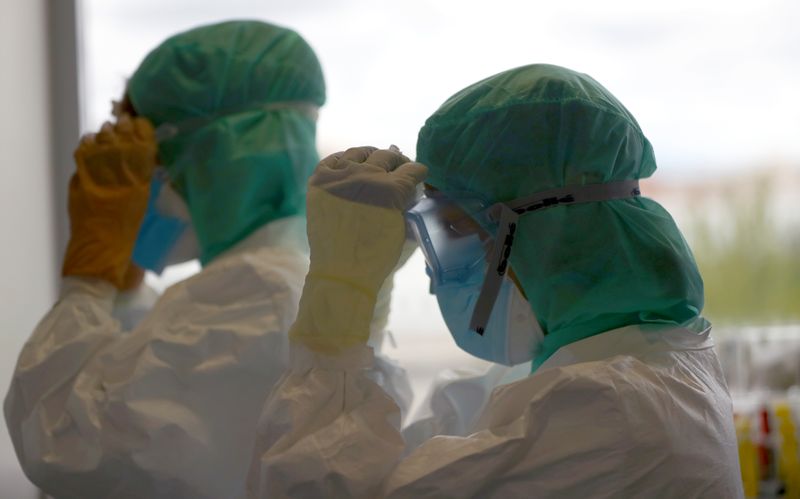 &copy; Reuters. Profissionais de saúde com trajes de proteção na UTI de hospital em Madri