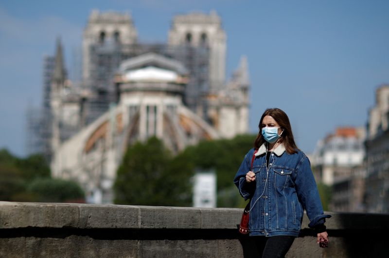 &copy; Reuters. Una mujer con mascarilla pasa por delante de la catedral de Notre-Dame en París, Francia, el 27 de abril de 2020