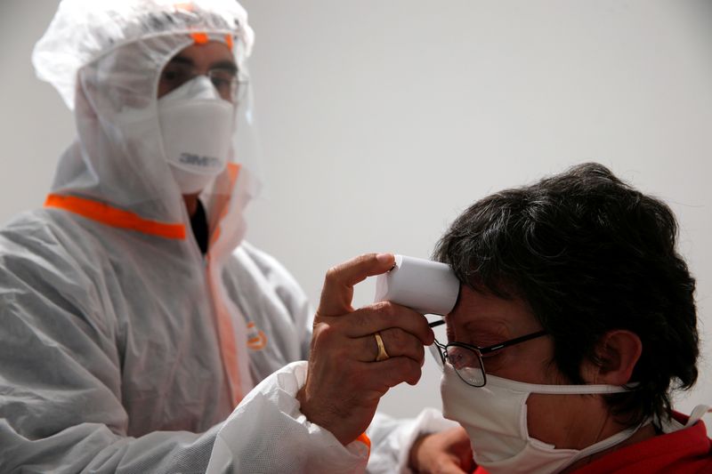 &copy; Reuters. Médico com trajes de proteção mede temperatura em Gouzeaucourt, na França