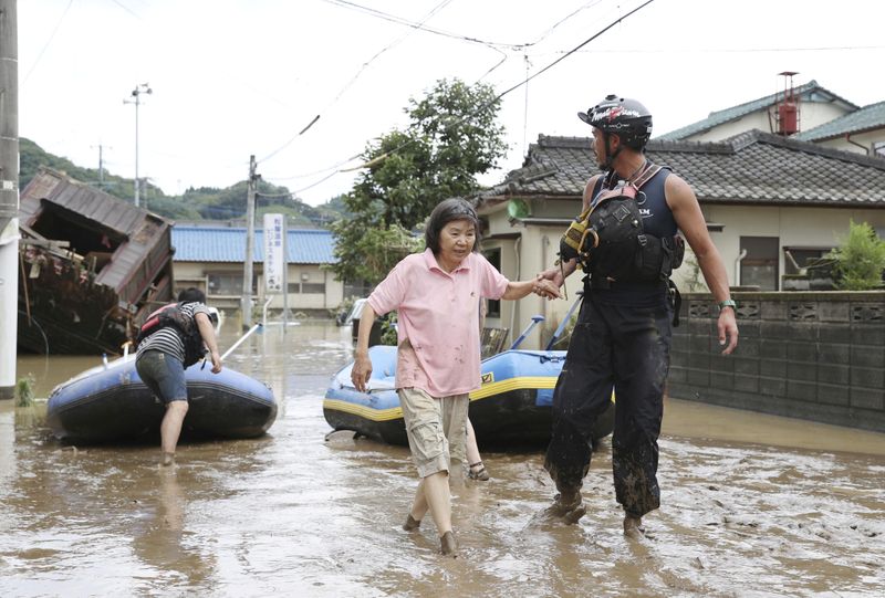 &copy; Reuters. Un rescatista ayuda a los residentes locales en una zona inundada causada por una fuerte lluvia a lo largo del río Kuma en Hitoyoshi, prefectura de Kumamoto, en el sur de Japón, el 4 de julio de 2020