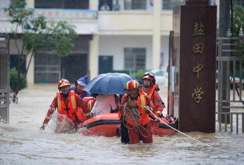 &copy; Reuters. Rescue workers evacuate students stranded by floodwaters at a school, amid heavy rainfall in Duchang county