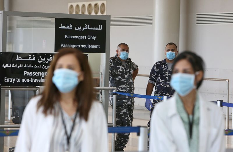 &copy; Reuters. Health workers and members of internal security forces wearing face masks stand inside Beirut international airport