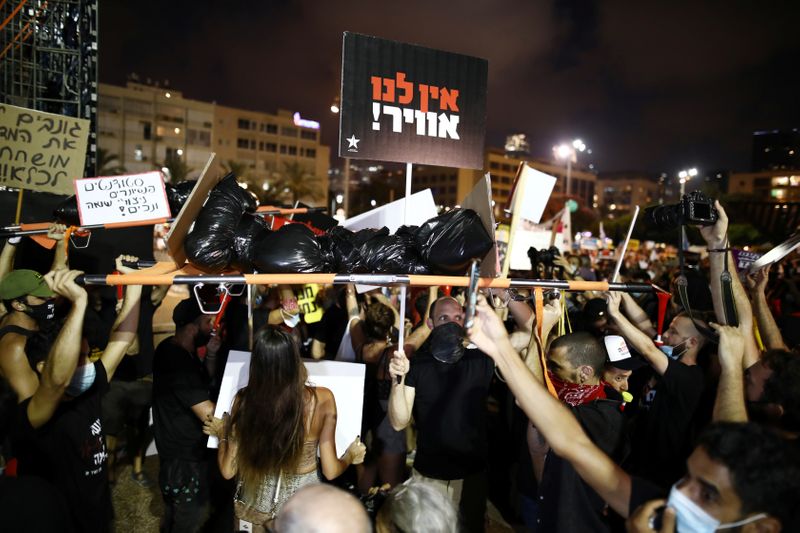 &copy; Reuters. Israelis carry a stretcher as they protest against the government&apos;s response to the financial fallout of the coronavirus disease (COVID- 19) crisis at Rabin square in Tel Aviv