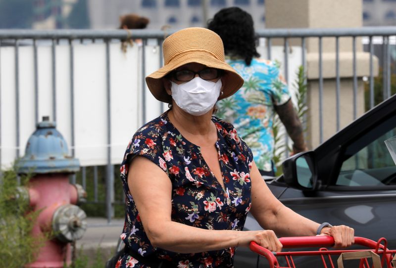 &copy; Reuters. People wear protective face masks outside at a shopping plaza in Edgewater New Jersey