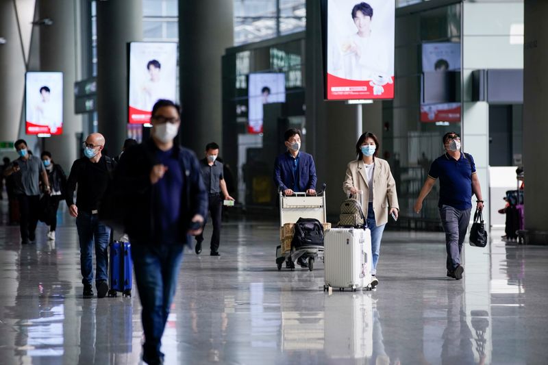 &copy; Reuters. FILE PHOTO: People wearing face masks are seen at Hongqiao International Airport in Shanghai