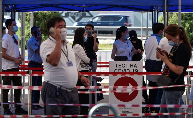 &copy; Reuters. Люди в очереди у станции тестирования на коронавирус в Алма-Ате