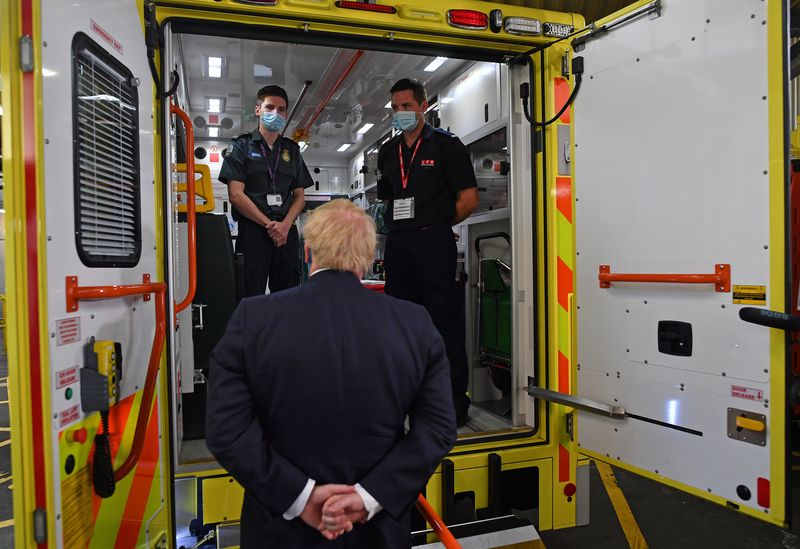 &copy; Reuters. Il primo ministro britannico Boris Johnson parla con il paramedico Jack Binder e il vigile del fuoco Tom Binder mentre visita il quartier generale del servizio di ambulanze di Londra Nhs Trust, a Londra,