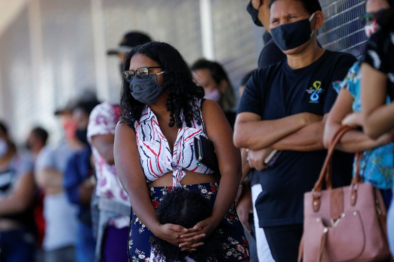 &copy; Reuters. Pessoas com máscaras de proteção fazem fila para serem atendidas em banco em Ceilândia, no Distrito Federal