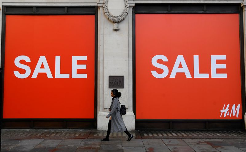 &copy; Reuters. A woman walks past a sale sign on a branch of H&amp;M on Oxford Street in London