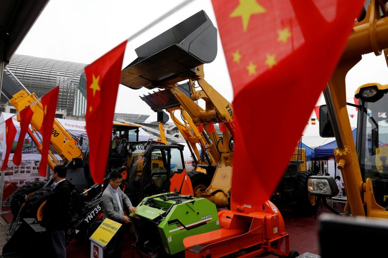 © Reuters. FILE PHOTO: Chinese flags are seen in front of construction vehicles during the China Import and Export Fair, also known as Canton Fair, in the southern city of Guangzhou