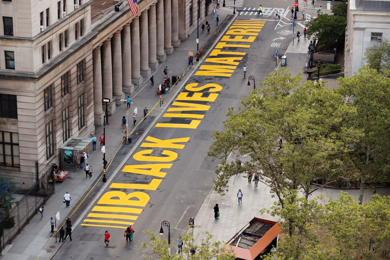 &copy; Reuters. FILE PHOTO: Pedestrians walk past a large &quot;Black Lives Matter&quot; banner painted on a street near the Brooklyn borough hall in New York City, New York