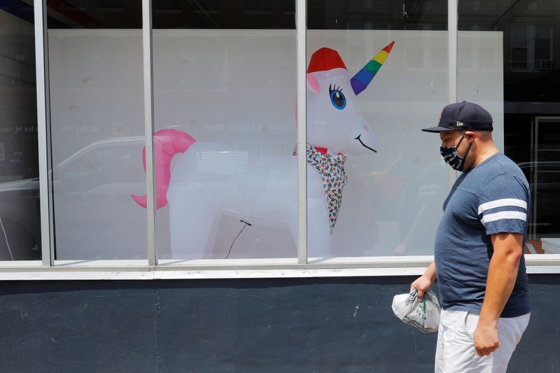 © Reuters. A pedestrian passes a storefront with an inflated unicorn in the window in Chelsea