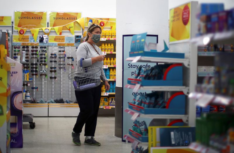 &copy; Reuters. A woman wearing a protective face mask is seen in a shop, in London