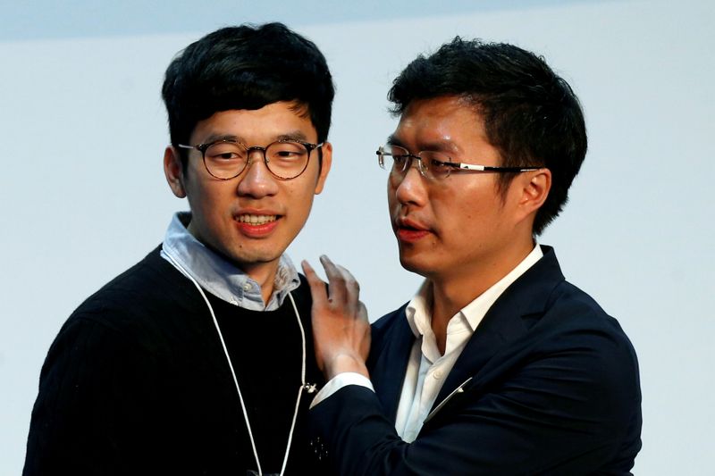 © Reuters. FILE PHOTO: Pro-democracy candidate Au Nok-hin celebrates with disqualified lawmaker Nathan Law after winning in the Legislative Council by-election in Hong Kong