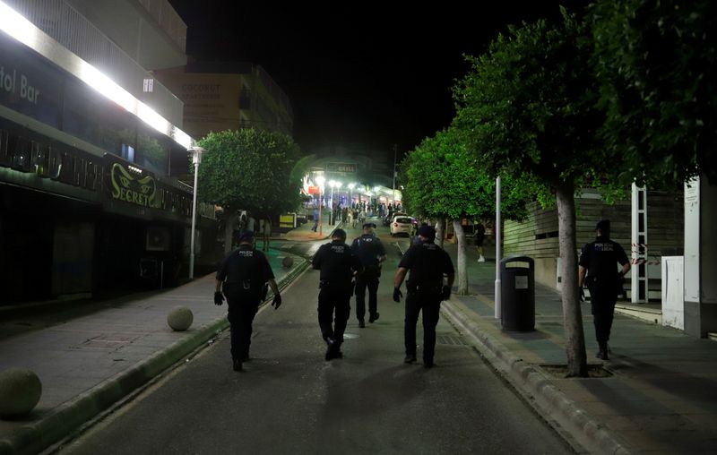 &copy; Reuters. FOTO DE ARCHIVO: Agentes de la policía con mascarillas patrullan la calle Punta Ballena en Magaluf, Mallorca, España