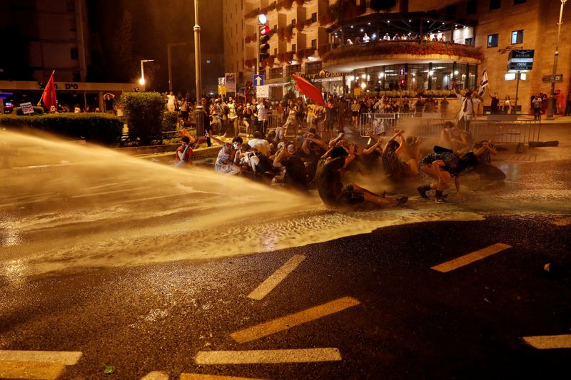 © Reuters. FILE PHOTO: Police use water cannons as they clash with people during a protest against Israeli PM Netanyahu and his government's response to the financial fallout of the coronavirus disease  crisis outside Netanyahu's residence in Jerusalem