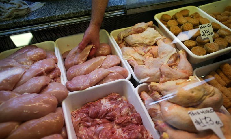 &copy; Reuters. A vendor places chiken breasts for sale in a poultry shop in a market in Buenos Aires
