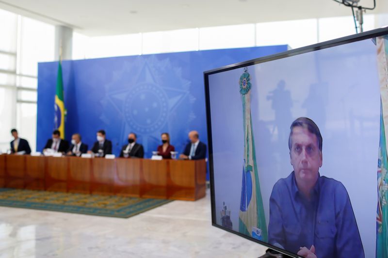 &copy; Reuters. Brazil&apos;s President Jair Bolsonaro is seen on a screen as he attends via video a conference of the launching ceremony of the basic sanitation legal framework at the Planalto Palace, in Brasilia