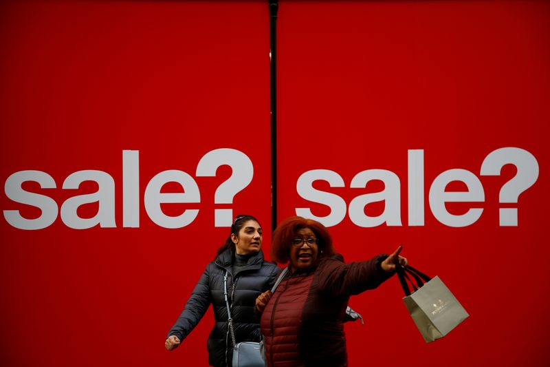 &copy; Reuters. Pedestrians walk past a sign of a shop window in the West End, in London