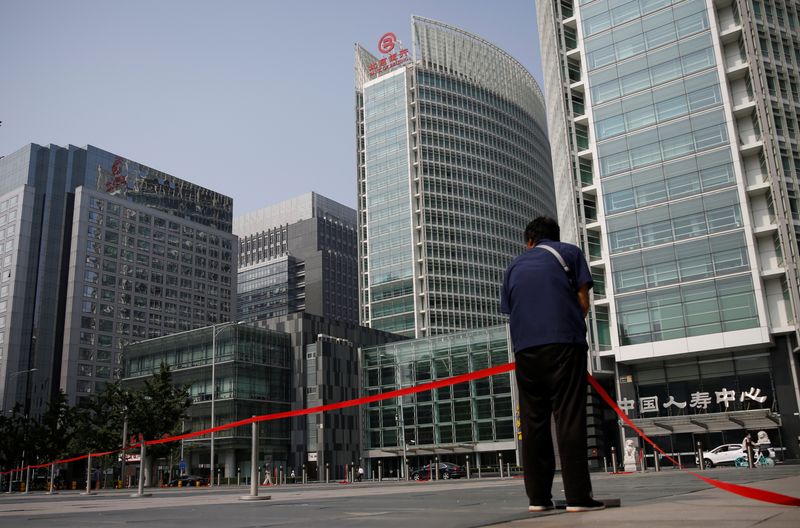 &copy; Reuters. Worker wearing a face mask following the outbreak of the coronavirus disease (COVID-19) sets up a line at a square at the Financial Street area in Beijing