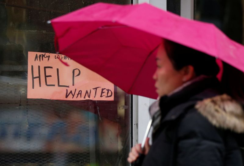 &copy; Reuters. A woman walks past a &quot;Help wanted&quot; sign at a retail store in Ottawa