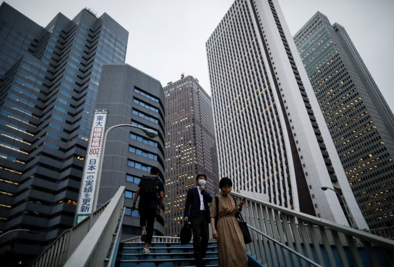 &copy; Reuters. Passersby wearing protective face masks walk as the spread of the coronavirus disease (COVID-19) continues, in Tokyo