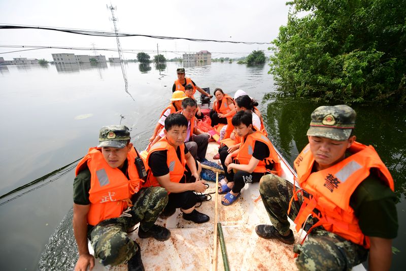 &copy; Reuters. Oficiales de policía evacuan a los residentes de una aldea inundada en el condado de Yongxiu de Jiujiang, provincia de Jiangxi, China, el 14 de julio de 2020