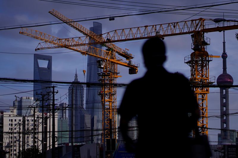 &copy; Reuters. A man walks in front of Lujiazui financial district in Shanghai