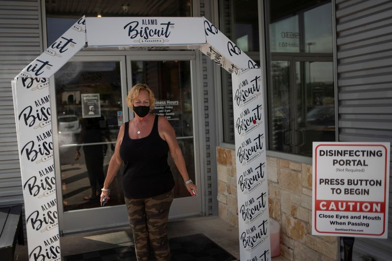 © Reuters. Local resident walks through disinfection station before entering restaurant amid global outbreak of coronavirus disease in San Antonio