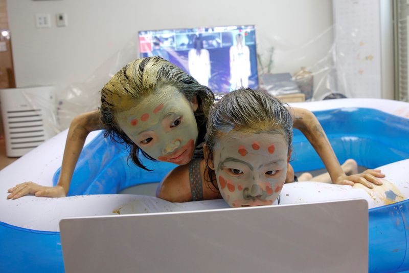 &copy; Reuters. Children play in a mud pool during the Online Boryeong Mud Festival at their home during a live streaming event, in Gwangju