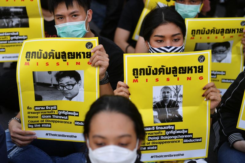 © Reuters. Protesters hold posters with missing students pictures during a protest demanding the resignation of the government, in Bangkok