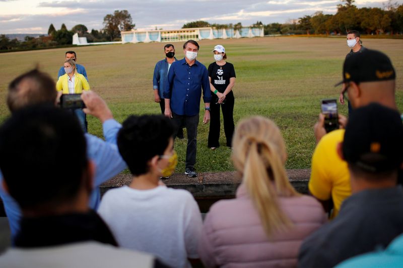 &copy; Reuters. El presidente de Brasil, Jair Bolsonaro, habla con partidarios en terrenos del Palacio Alvorada, en medio del brote de coronavirus, en Brasilia