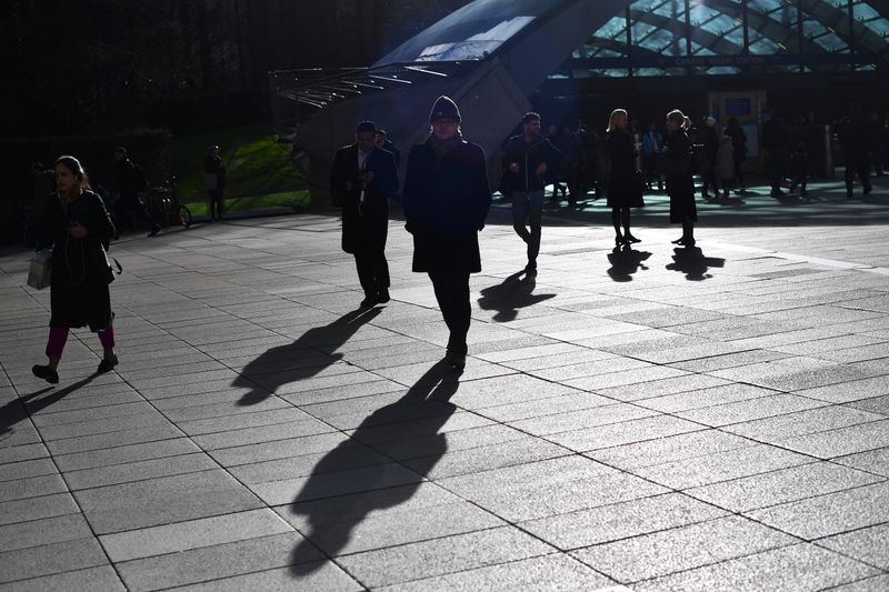 &copy; Reuters. Commuters walk through Canary Wharf in London