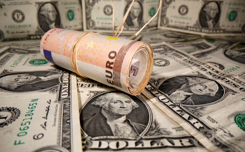 © Reuters. FILE PHOTO: Rolled Euro banknotes are placed on U.S. Dollar banknotes