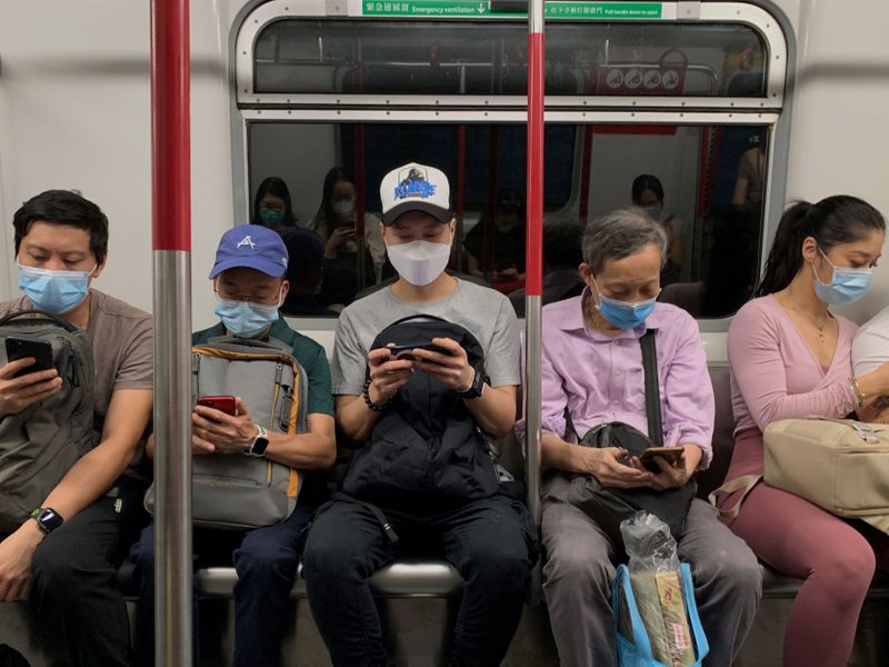© Reuters. Varios pasajeros con mascarillas en un tren MTR train en Hong Kong, China.