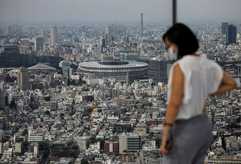 © Reuters. The National Stadium, the main stadium of Tokyo 2020 Olympics and Paralympics, is seen through a visitor wearing a protective face mask amid the coronavirus disease (COVID-19) in Tokyo
