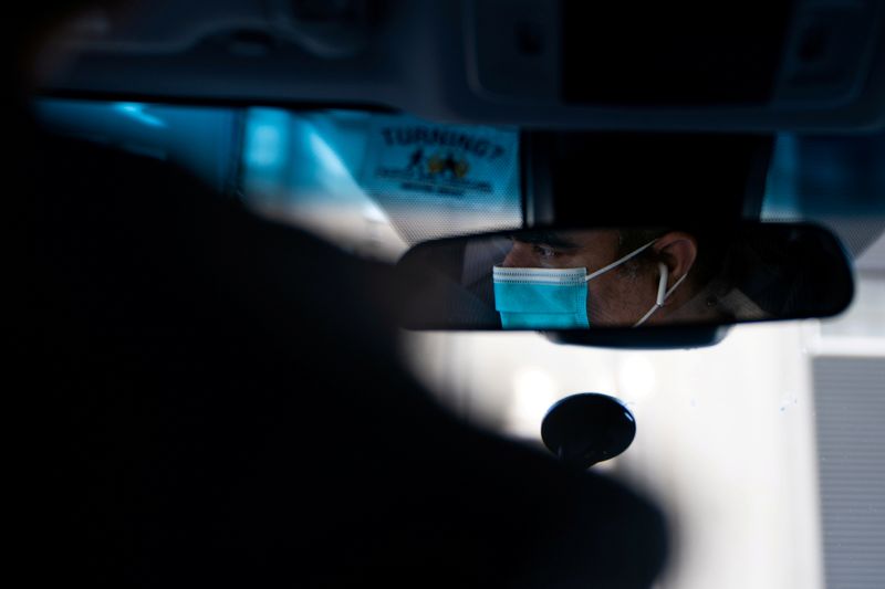 &copy; Reuters. FILE PHOTO: An Uber driver in a surgical mask is seen in a mirror in the Manhattan borough following the outbreak of the coronavirus disease