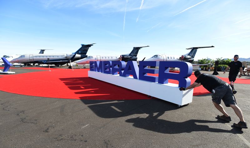 &copy; Reuters. Workers set up at the Embraer booth prior to the opening of the National Business Aviation Association (NBAA) exhibition in Las Vegas
